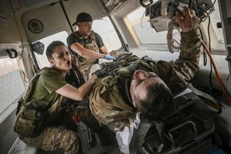 Украинские военные медики эвакуируют военнослужащего, раненного на фронте в районе города. 23 марта 2023-го