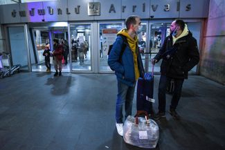 Россияне и белорусы с вещами ждут такси у дверей аэропорта в Ереване. 10 марта 2022 года