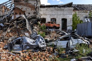 Разбитые автомобили под завалами разрушенного дома в Изюме