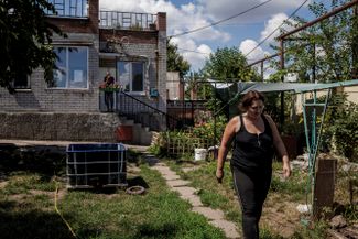50-летняя Галина Кочерга, в доме которой живут беженцы из восточных регионов Украины, идет по своему саду