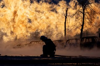 Пожарный тушит загоревшийся газопровод, поврежденный российским снарядом