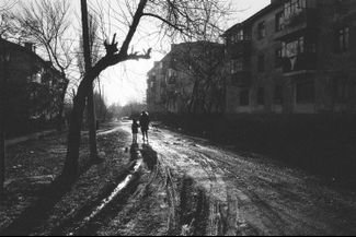 Мама прогуливается с ребенком по улице города Снежное в Донецкой области. 25 февраля 2002 года