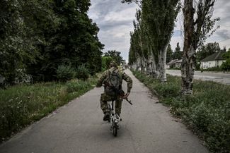 Украинский военный едет на маленьком велосипеде в Лисичанске