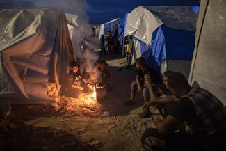 Вынужденные переселенцы из северных и центральных районов сектора Газа готовят пищу на открытом огне в лагере беженцев в городе Хан-Юнис на юге сектора, 31 октября 2023 года. По данным ООН, после 7 октября покинуть свои дома пришлось 1,4 миллиона жителей Газы