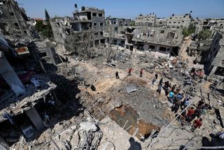 Палестинцы оценивают ущерб, причиненный израильскими авиаударами, в городе Бейт-Ханун на севере сектора Газа. 14 мая 2021 года