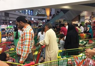 Люди покупают товары первой необходимости в супермаркете в Дохе. Июнь 2017 года
