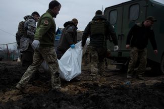 Украинские врачи забирают тело солдата из прифронтового района. Эвакуаторы круглосуточно вывозят погибших и помогают пострадавшим
