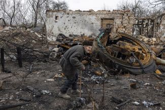 98-летний мужчина проходит мимо своего сгоревшего дома и подбитого российского танка. Село Слобода под Черниговом