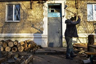 Житель Северска рубит дрова для самодельного печного отопления своей квартиры. Центральное отопление не работает во многих прифронтовых городах Донецкой области