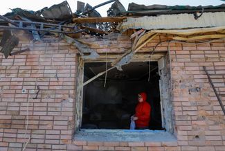 55-летняя Юлия в окне своего дома, поврежденного во время украинского обстрела