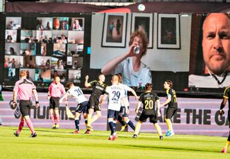 Футбольный матч между датскими командами AGF и Randers FC в городе Орхус. Изображения сидящих дома болельщиков транслируются на экранах. Дания, 28 мая 2020 года