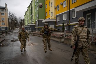 Украинские солдаты пинают мяч в Ирпене.