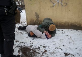 Военнослужащий оказывает помощь женщине, раненой в результате ракетного удара в Краматорске. 2 февраля 2023 года