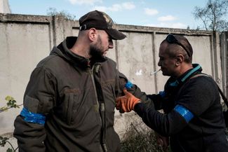 Украинские солдаты в освобожденном селе повязывают друг другу на рукава синюю изоленту — отличительный знак ВСУ