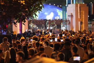 Tbilisi residents who missed Ye's concert watch the show outside the stadium, June 12, 2026