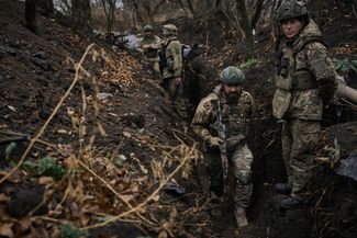Бойцы 58-й отдельной механизированной бригады ВСУ идут на позиции вдоль траншей, размытых после дождя. 6 ноября 2023 года
