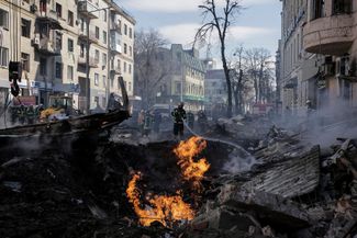 Пожарные тушат огонь возле жилого дома после ракетного обстрела Харькова, 14 марта