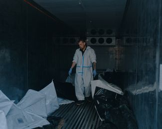 A morgue worker next to the bodies of the missile strike’s victims.