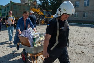 Волонтеры увозят учебники из разрушенной гимназии.