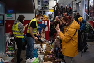 Волонтеры раздают товары для домашних животных украинцам на главном железнодорожном вокзале Кракова, 13 марта 2022 года