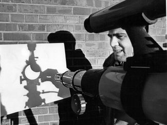 Астроном-любитель Ральф Мерлетти проецирует через телескоп солнечное затмение на лист бумаги в Денвере 13 декабря 1974 года. Среди астрономов известна черная шутка, что на Солнце в телескоп своими глазами можно посмотреть два раза. Чтобы избежать повреждения глаз ярким солнечным светом и одновременно использовать телескопические наблюдения такого впечатляющего события, как затмение, астрономы давно придумали простой прием проецирования света через телескоп на ровную поверхность, которая не боится интенсивного солнечного излучения. Таким образом без специальной техники и защитных фильтров можно наблюдать солнечные пятна или моменты прохождения Луны на фоне Солнца.