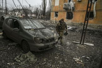 Украинский военный у поврежденного автомобиля в Часовом Яре