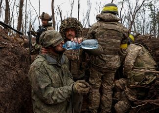 Украинский солдат и российский военнопленный на позиции, захваченной в результате контратаки