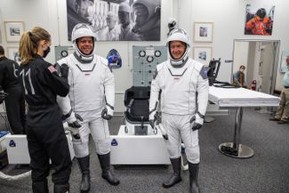 Роберт Бенкен (слева) и Дуглас Херли надевают скафандры перед запуском SpaceX Demo-2. 30 мая 2020 года. 