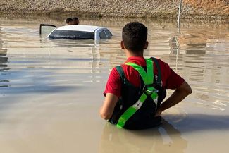 Сотрудники Красного Полумесяца осматривают автомобили, пострадавшие от наводнения на востоке Ливии, 11 сентября 2023 года