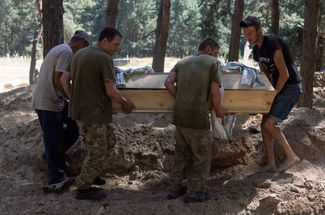 Сдавшиеся в плен украинские солдаты хоронят гробы с неопознанными телами погибших сослуживцев в Старобельском районе самопровозглашенной ЛНР