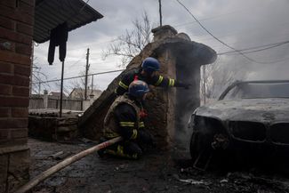 Украинские спасатели пытаются потушить пожар, одновременно укрываясь от взрывов