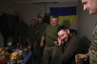Украинские военные за праздничным столом в Донецкой области. Командир поздравляет по рации своих подчиненных, находящихся на боевых позициях