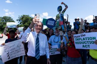 Сенатор-демократ Эд Марки вместе с активистами против изменения климата отмечает принятие законопроекта Inflation Reduction Act на ступеньках Капитолия. 7 августа 2022 года