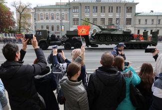 Зрители приветствуют военную технику после парада на Красной площади. Москва, 9 мая 2023 года