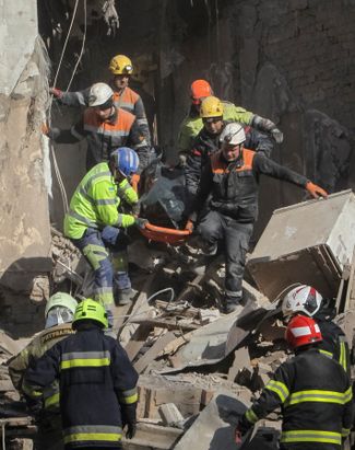 Rescuers remove the body of the deceased who was found under the rubble of a house in the Dnieper River, April 25, 2026.