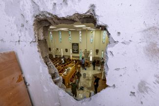 Сотрудники израильской службы безопасности осматривают синагогу в городе Ашкелон, после попадания в нее ракеты, 16 мая 2021