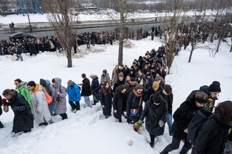 Люди, пришедшие проститься с Алексеем Навальным, идут от храма к Борисовскому кладбищу