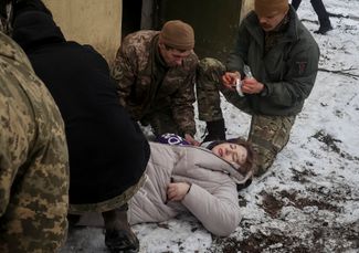 Украинские военные помогают раненой жительнице Краматорска