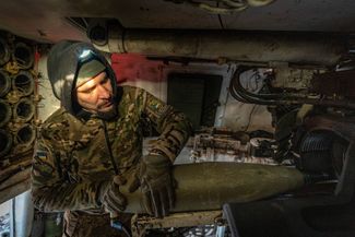 Боец ВСУ загружает снаряд в САУ М109