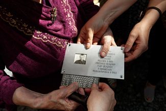 Memorial plaque for Alexey Andriyashin in the hands of his daughter, Tamara
