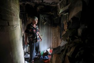 Житель Донецка осматривает свою квартиру, поврежденную в результате обстрела