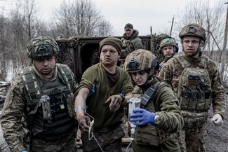 Медики ВСУ оказывают помощь раненому украинскому солдату в окрестностях Бахмута
