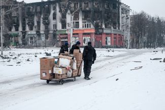 Украинские волонтеры везут на тележке гуманитарную помощь для оставшихся в Бахмуте мирных жителей