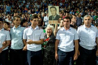 Женщина держит в руках портрет первого президента Абхазии Владислава Ардзинба