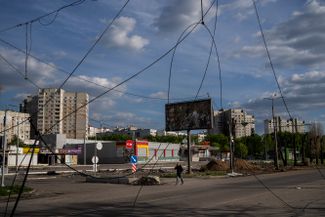 Житель Харькова идет мимо оборванных линий электропередач