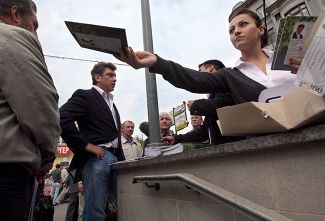 Борис Немцов раздает доклад «Лужков. Итоги» у станции метро «Третьяковская», Москва, 8 сентября 2009 года