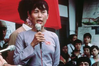 Аун Сан Су Джи выступает перед протестующими против правящего режима в столице Мьянмы. 1 июля 1989 года