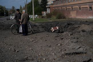 Жители Краматорска возле воронки от взрыва российского снаряда