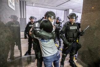 Участница акции протеста в Лексингтоне обнимает полицейского, который опустился на колени в знак солидарности с демонстрантами, 31 мая 2020 года