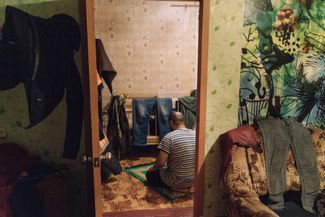 In the house of four Kazakh workers. In this photo, one of the Muslim men is praying in the sleeping room.
